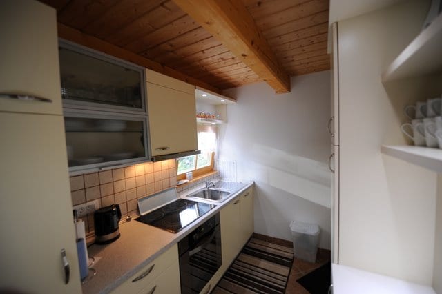 The cabin kitchen with fitted units, an extractor hood and a pine-boarded ceiling.